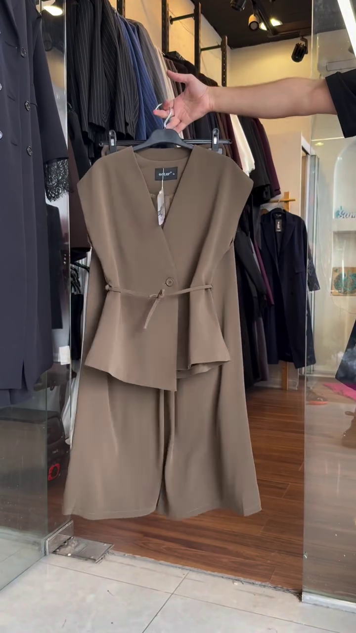 Powerfully Elegant: Chic Brown Pantsuit with Asymmetrical Sleeveless Vest and Wide-Leg Trousers